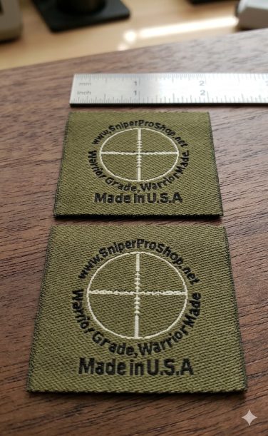 close-up photograph of woven labels showing micro-text with ruler showing scale, demonstrating legibility of small text