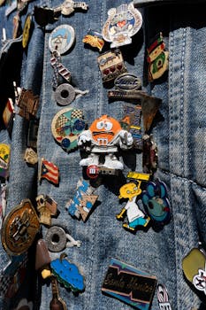 A vibrant collection of pins displayed on a blue denim jacket, showcasing diverse designs and themes.