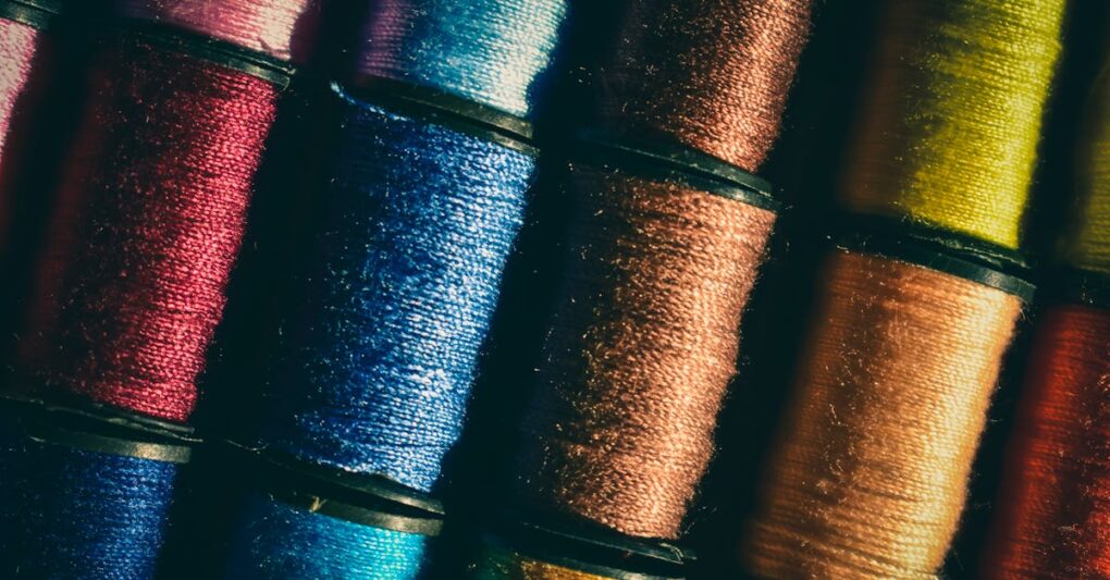 A detailed photo showcasing various colorful thread spools neatly stacked, highlighting their vivid hues.