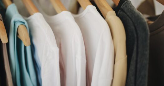 pexels-photo-3735641-3735641 A selection of colorful clothes neatly hanging on wooden hangers in a retail store.