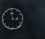 Chalk-drawn clock on a blackboard, symbolizing time and education concepts.
